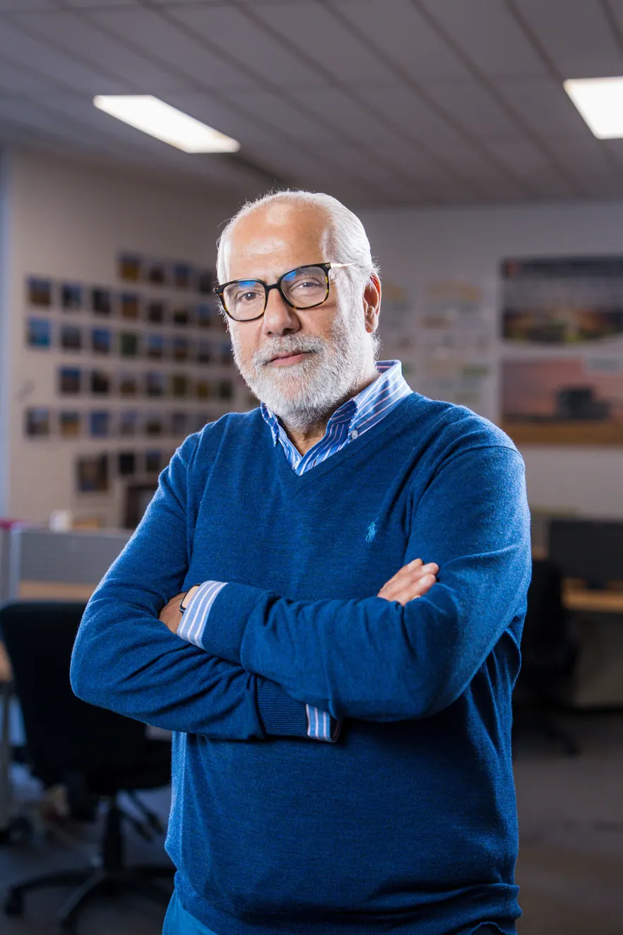 Portrait corporate debout au bureau, bras croisés : collaborateur en pull bleu