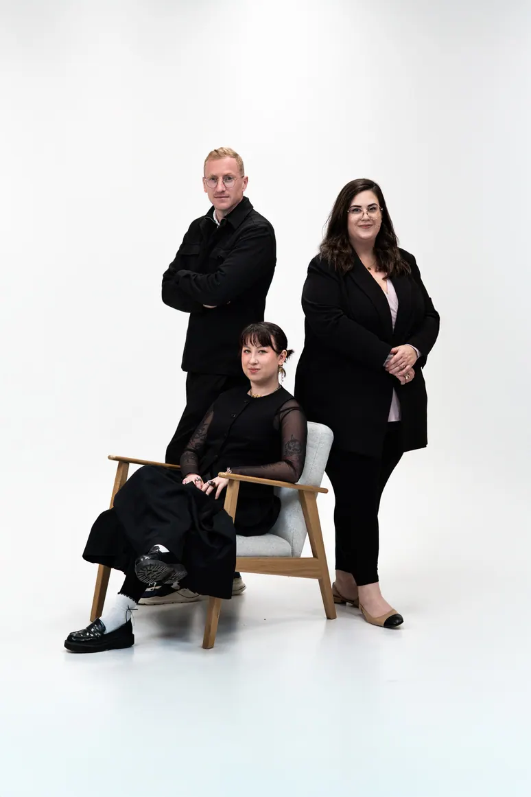 Trois personnes en studio blanc, une assise